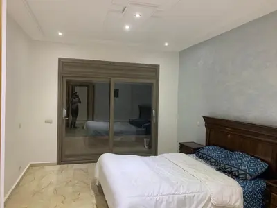 a bedroom with a large bed and a mirror at Villa ChezMoi in Oulad Tayeb