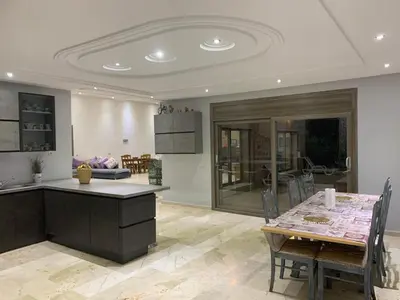 a kitchen and dining room with a table and chairs at Villa ChezMoi in Oulad Tayeb