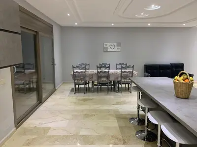 a kitchen and dining room with a table and chairs at Villa ChezMoi in Oulad Tayeb