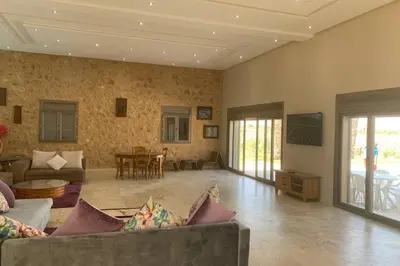 a living room with a couch and a table at Villa ChezMoi in Oulad Tayeb