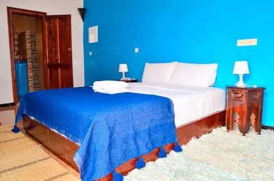 a blue bedroom with a bed and a blue wall at Kasbah Tussna in Boumalne