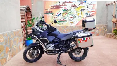 a motorcycle parked in a room with a mural at Kasbah Tussna in Boumalne