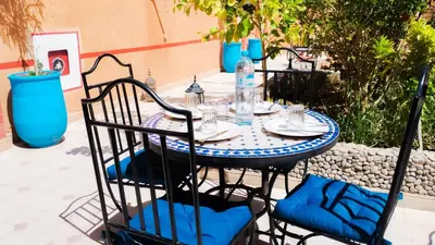 a table with two chairs and a blue and white table at Kasbah Tussna in Boumalne