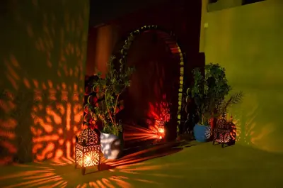 a dark room with two vases with plants and lights at Kasbah Tussna in Boumalne