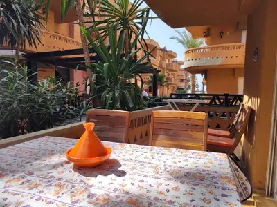 a table with an orange bowl on top of it at Appartement high standing piscine jardin mer proche Mohammedia in Figuiq