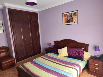 a bedroom with a bed with a colorful striped blanket at Appartement high standing piscine jardin mer proche Mohammedia in Figuiq