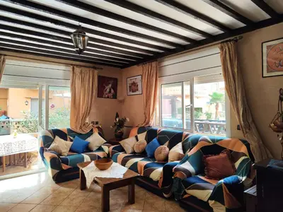 a living room with a couch and windows at Appartement high standing piscine jardin mer proche Mohammedia in Figuiq
