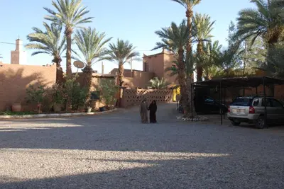 two people standing in the middle of a street with palm trees at Paradise in the southern desert Morocco in Tamegroute