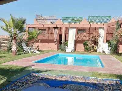 a swimming pool in the yard of a house at Riad Darga Rouge in Marrakech