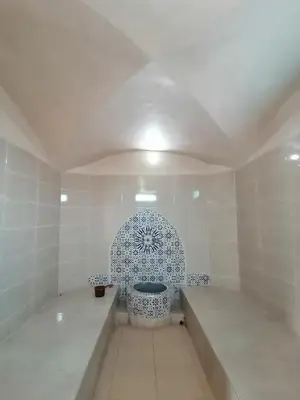 a bathroom with a toilet in a white room at Riad Darga Rouge in Marrakech