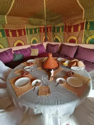 a table with plates and utensils on a couch at Riad Darga Rouge in Marrakech