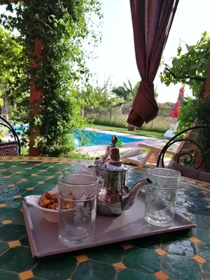 a tray with a tea pot and glasses on a table at Riad Darga Rouge in Marrakech