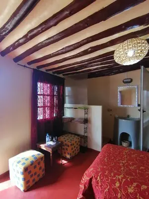 a bedroom with a red bed and a wooden ceiling at Riad Darga Rouge in Marrakech
