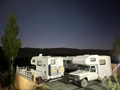 a white truck parked next to a recreational vehicle at Auberge & Restaurant Agoudal in Agoudal