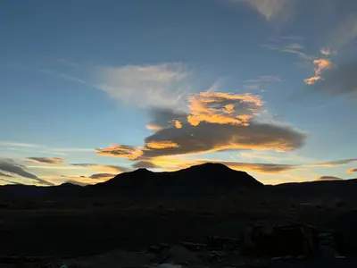 a sunset in the desert with a mountain in the background at Auberge & Restaurant Agoudal in Agoudal