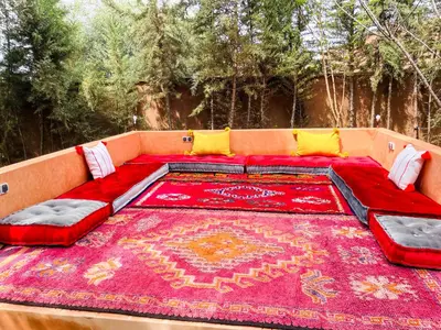 a large red couch with a red rug on it at Ilafe Farmhouse, Villa avec Piscine Chauffée Privée pour Familles in Marrakech