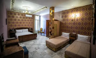 a hotel room with two beds and a chair at Palais Shazam & SPA in Fès