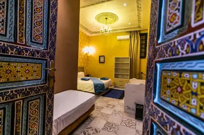 a room with two beds and a room with a door at Palais Shazam & SPA in Fès