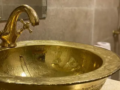 a gold sink with a faucet in a bathroom at Palais Shazam & SPA in Fès