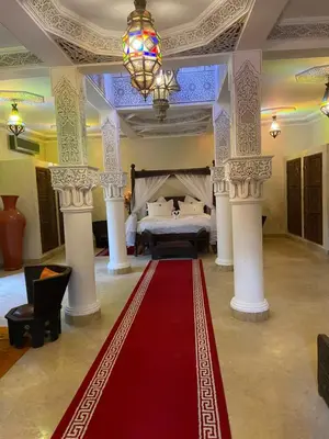 a large room with a red carpet in front of a bed at LES JARDINS DE MARRAKECH in Marrakech