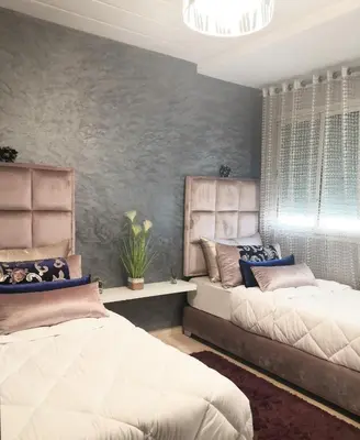 a bedroom with two beds and a gray wall at Luxury apart in Fes monumental Exclusively for the family in Fès