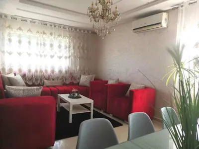 a living room with red couches and a table at Luxury apart in Fes monumental Exclusively for the family in Fès