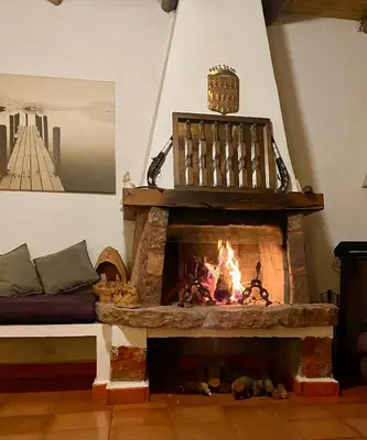 a living room with a fireplace and a couch at Villa sur le lac Bin el ouidane in Aït Irizane