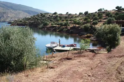 a boat is docked in the water on a river at Villa sur le lac Bin el ouidane in Aït Irizane