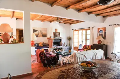 a living room with a table with a bowl of fruit on it at Villa sur le lac Bin el ouidane in Aït Irizane