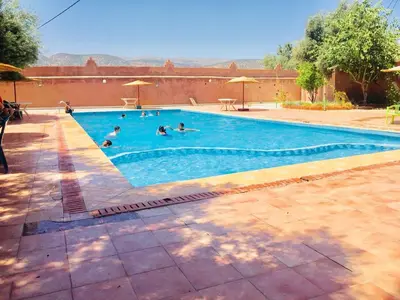 a group of people swimming in a swimming pool at Hotel France Ouzoud in Ouzoud