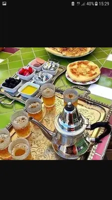 a table with a tea kettle and glasses of beer at Hotel France Ouzoud in Ouzoud
