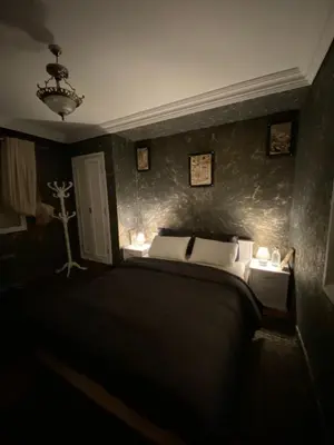 a bedroom with a bed in a dark room at Très joli appartement au centre de IFRANE in Ifrane
