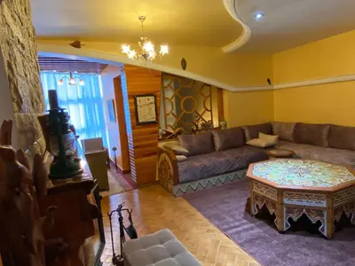 a living room with a couch and a table at Très joli appartement au centre de IFRANE in Ifrane
