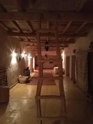 a large room with a wooden ceiling with a ladder at Kasbah Timdaf in Demnat