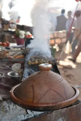 a pot cooking food on a grill with smoke at Kasbah Timdaf in Demnat