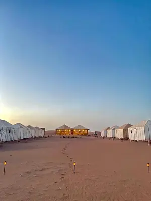 a beach with many tents and footprints in the sand at Chegaga Starlight Camp - Mhamid Desert Haven in Mhamid