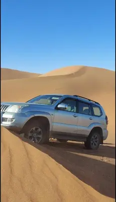a suv parked in the sand in the desert at Chegaga Starlight Camp - Mhamid Desert Haven in Mhamid