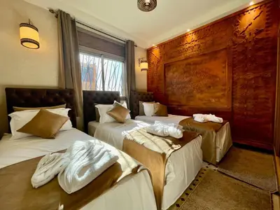 a hotel room with two beds with towels on them at Merzouga Hotel Lexpert 