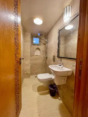 a bathroom with a white toilet and a sink at Merzouga Hotel Lexpert 