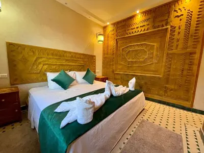 a hotel room with two beds with towels on them at Merzouga Hotel Lexpert 