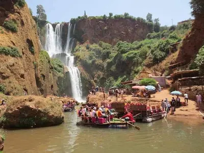 a group of people on boats in the water near a waterfall at Dar rachid ouzoud in Azilal