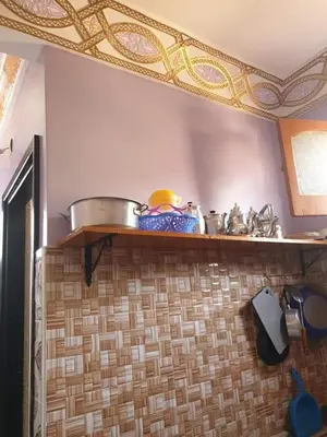 a kitchen with a shelf with pots and pans on it at Dar rachid ouzoud in Azilal