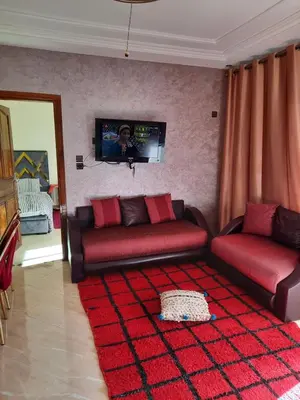 a living room with two red couches and a tv at DARY in Fès