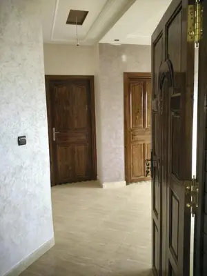 an empty room with two wooden doors in it at DARY in Fès