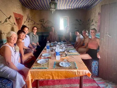 a group of people sitting around a table at Tamaris Camp in Hassilabied