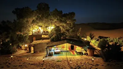 a house in the middle of the desert at night at Tamaris Camp in Hassilabied