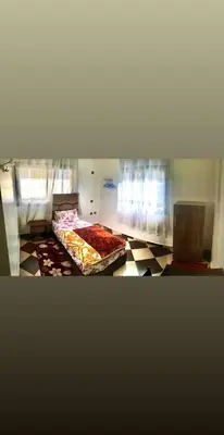 a room with two beds on a tiled floor at ZELLAKA hôtel & café in Khouribga