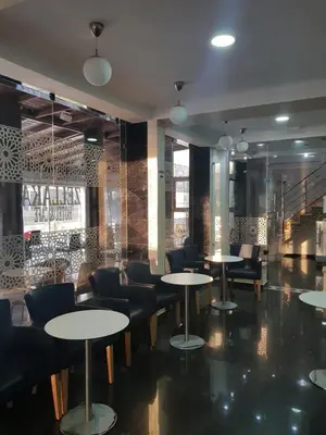 a restaurant with tables and chairs in a room at ZELLAKA hôtel & café in Khouribga