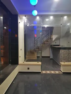 an empty room with a staircase with blue lights at ZELLAKA hôtel & café in Khouribga