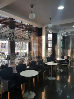 a restaurant with tables and chairs in a room at ZELLAKA hôtel & café in Khouribga